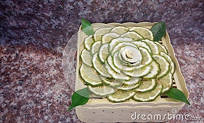 Juicy slice Makrut or Kaffir lime with green Bergamot on wood table Stock Photo