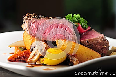 Juicy steak with baked potatoes and mushrooms Stock Photo