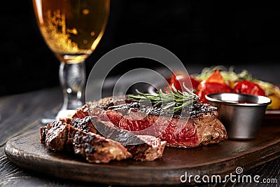 Juicy steak medium rare beef with spices on wooden board on table Stock Photo