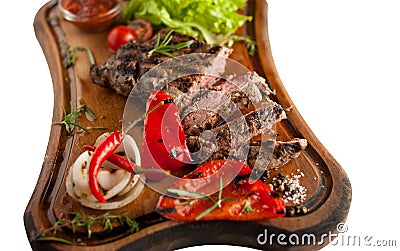 Juicy steak from marbled beef with vegetables on a wooden board. Sliced. Isolated Stock Photo