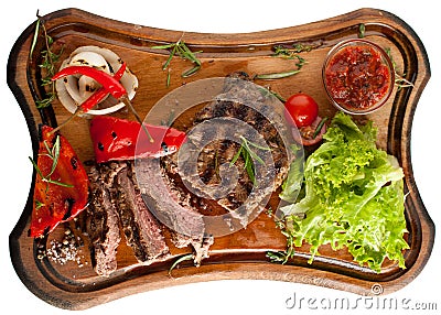 Juicy steak from marbled beef with vegetables on a wooden board. Sliced. Isolated Stock Photo