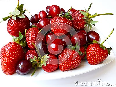 Juicy strawberries and cherries on white plate Stock Photo