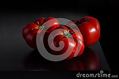 Juicy tomatoes on a wooden dark background Stock Photo