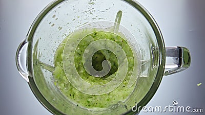 Juicy vegetables blended mixer swirling inside bowl closeup in super slow motion Stock Photo