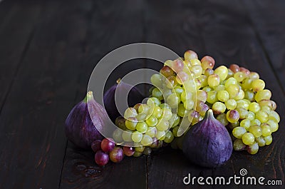 Juicy yellow, green raisins and several ripe blue figs on a dark wooden background. fresh fruits, natural vitamin, vegetarian food Stock Photo