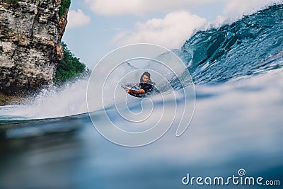 July 12, 2020. Bali, Indonesia. Surfer ride on bodyboard at wave. Surfing in Padang Padang Editorial Stock Photo