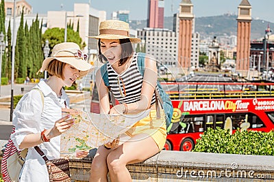 Two happy tourists looking at the map while traveling in Barcelona, near Venetian Towers and Spain Editorial Stock Photo