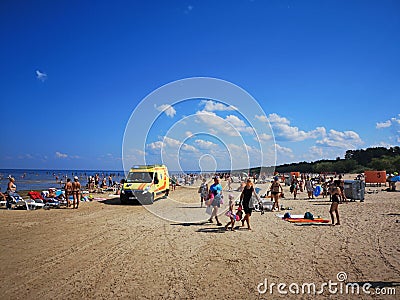 July 28, 2019. Beach in Vecaki, Latvia. Hot sunny summer Day +32C. Ambulance on the beach Editorial Stock Photo