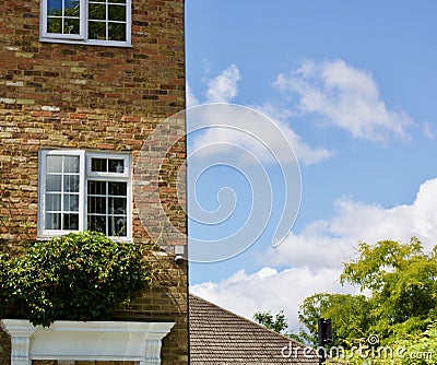 11 July 2020 - England, UK: Suburban townhouse against blue cloudy sky Editorial Stock Photo