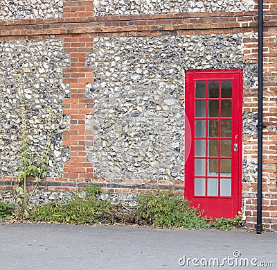 25 July 2020 - England, United Kingdom: Door of red telephone box built into wall Editorial Stock Photo