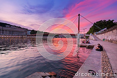 Cityscape of Lyon city at sunset with red footbridge leading to Courthouse Palais de Justice over Editorial Stock Photo