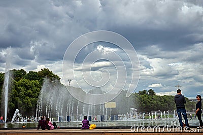 06 July 2019 Moscow, Russia. Tourists and locals rest in Gorky park. Summer cloudy sky before rain and a beautiful splashing Editorial Stock Photo