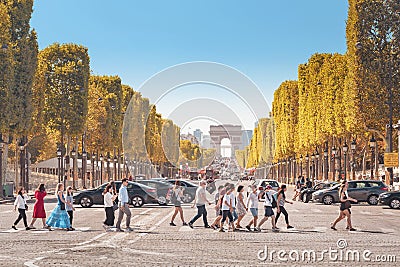 pedestrians crossing over the Avenue Champs Elysees at the background of Arch de Triumph Editorial Stock Photo