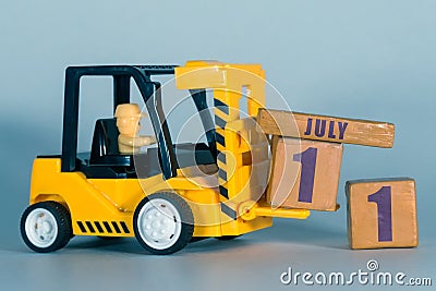 july 11th. Day 11 of month, Construction or warehouse calendar. Yellow toy forklift load wood cubes with date. Work planning and Stock Photo