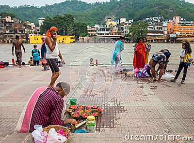 July 8th 2022 Haridwar India. A Man selling colorful flowers at the banks or ghats of river Ganges for the Hindu Rituals Editorial Stock Photo