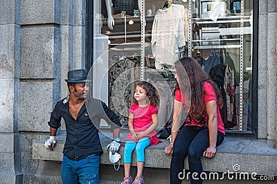 July 26, 2013. View of the streets of Oslo, Norway. Area of the center of Oslo. A migrant family with a child rests on the parapet Editorial Stock Photo