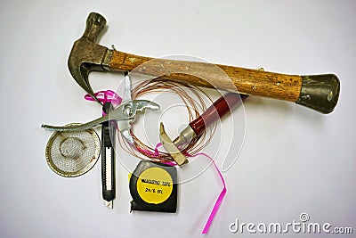 Jumble of hardware and tools piled together with pink ribbon Stock Photo