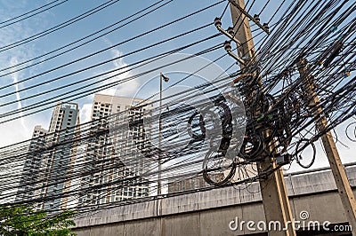 Jumble of overhead electricity and communication cables Stock Photo