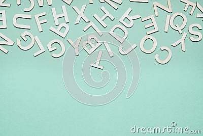 jumble of wooden letters falling down on blue paper background Stock Photo