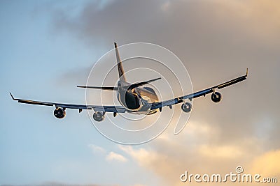 Jumbo jet four big engines flying off taking tourists abroad from airport on holiday into golden sunset summer sky. Stock Photo