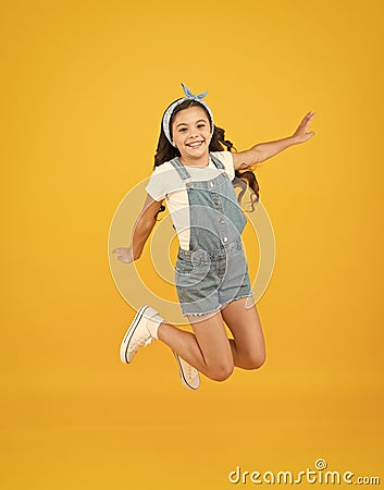 Jump of happiness. small girl jump yellow background. full of energy. Active girl feel freedom. Fun and relax. feeling Stock Photo