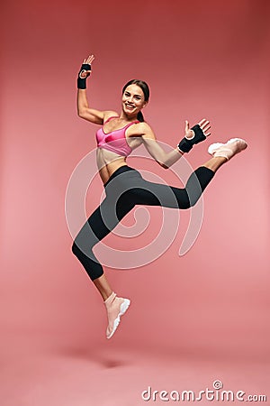 Jump Motion. Smiling Sports Woman Jumping In Sportswear Stock Photo