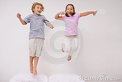 Jumping, bed and kids with fun, energy and morning in a bedroom with game and sibling. Youth, hop and home with a Stock Photo