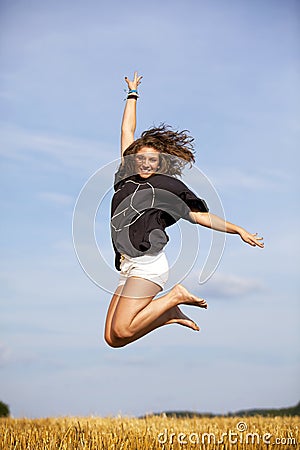 Jumping happy blond teenage girl Stock Photo