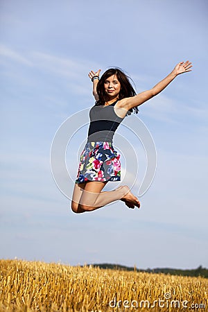 Jumping happy brunette teenage girl Stock Photo