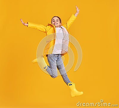 Jumping kid in raincoat and gumboots Stock Photo