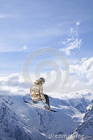A jumping snowboarder in the mountains. Snowboarding, winter extreme sport. Editorial Stock Photo