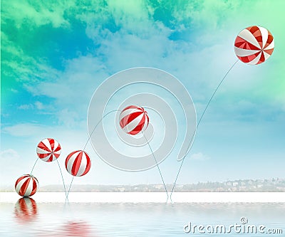 Jumping striped inflatable balls on beach with sea Stock Photo