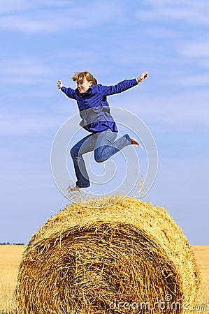 Jumping up on straw roll Stock Photo