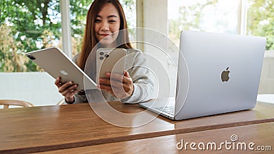 Jun 16th 2020 : A woman holding and using Iphone 11 Pro Max smart phone and Apple New Ipad Pro 2020 tablet pc with Apple Editorial Stock Photo