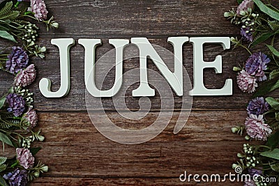 June alphabet letters with flower decoration on wooden background Stock Photo