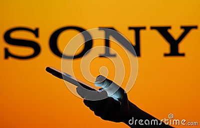 June 13, 2023, Brazil. Sony logo seen in the background of a silhouette woman holding a mobile Cartoon Illustration