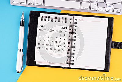 June 2024 calendar, notepad, pen and computer keyboard Stock Photo