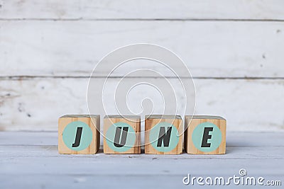 june concept written on wooden cubes or blocks, on white wooden background. Stock Photo