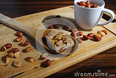 June party food called Festa junina. Typical Brazilian sweet called PÃ© de Moleque. Peanut candy on and roasted peanuts on wooden Stock Photo
