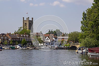 St Mary's Church of England tower overlooking the Thames with its boats and barge Editorial Stock Photo