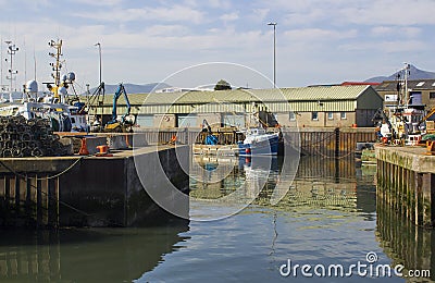 Various colourful fishing trawlers tied up in the calm waters of Kilkeel Harbour in County Down Northern Ireland Editorial Stock Photo