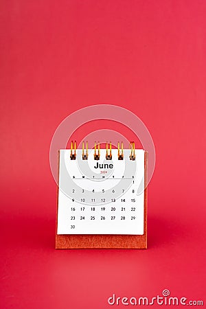 June 2024 white mini desk calendar on red background Stock Photo