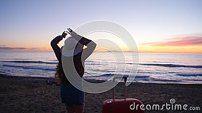 Junge Frau mit einem Koffer auf dem sonnigen Strand stock footage Junge Frau mit einem Koffer auf dem sonnigen Strand stock footage