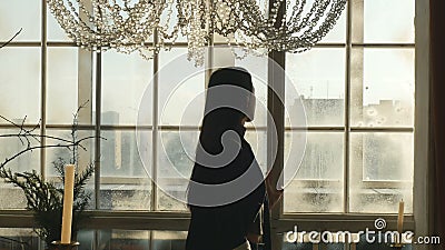 Junge Frau schaut heraus ein Winterfenster stock footage Junge Frau schaut heraus ein Winterfenster stock footage