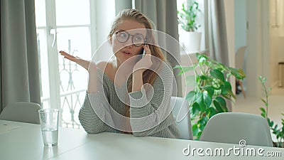 Junge lächelnde Frau, die zu Hause Telefon verwendet stock footage Junge lächelnde Frau, die zu Hause Telefon verwendet stock footage