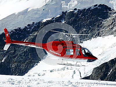 Jungfrau, Switzerlan, 08/06/2009. Red helicopter on high mountai Editorial Stock Photo