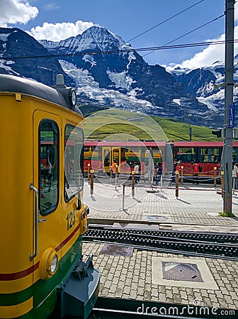 Jungfrau, Switzerland - August 19, 2019: Beautiful view of the alpine valley in the Jungfrau region. The train is at the railway Editorial Stock Photo