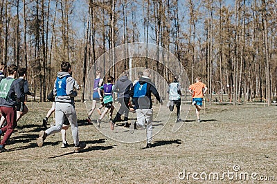 Junior competition. Young boys run through the woods, take part in the competition Editorial Stock Photo