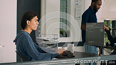 Junior developer writing database code to create new user interface on computer Stock Photo