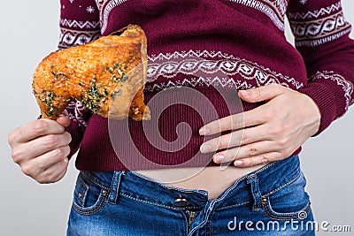 Junk food eating too much concept. Cropped close up photo of girl holding hands palm on big full abdomen feeling heartburn after Stock Photo